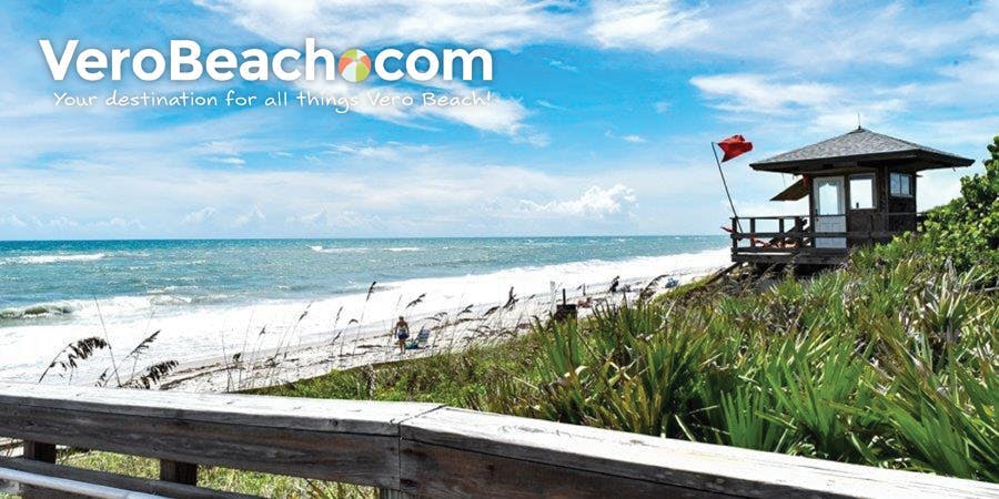 Dune walkover with lifeguard station flying red flag at beach in Vero Beach, Florida